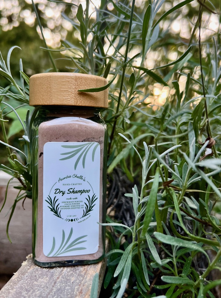 The Dry Shampoo jar standing among lavender stems