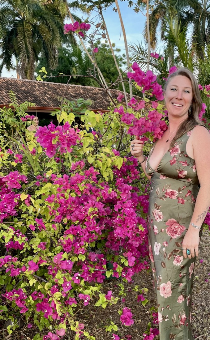 Michelle, maker of Auntie Chelle's, beside a bougainvillea